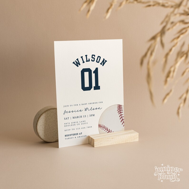 Peut inclure: Une invitation de f&ecirc;te pr&eacute;natale blanche avec du texte bleu qui dit "WILSON 01". L'invitation comprend les d&eacute;tails d'une f&ecirc;te pr&eacute;natale pour Jessica Wilson le 13 mars &agrave; 15h. L'invitation comprend &eacute;galement l'adresse et les informations de RSVP. Un graphique de baseball est partiellement visible dans le coin inf&eacute;rieur droit de l'invitation.