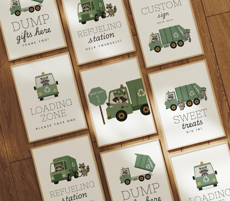 May include: A set of framed prints featuring green garbage trucks and raccoons. The prints display phrases such as "Dump Gifts Here," "Refueling Station," and "Loading Zone." The signs are displayed on a wooden surface.