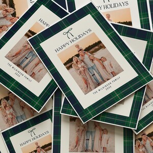 May include: Holiday cards with a family photo, featuring a green and navy plaid border. The cards have the text "HAPPY HOLIDAYS" and "THE WILKINSON FAMILY 20XX". The family photo shows a group of people on a beach.