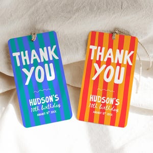 May include: Two rectangular gift tags with rounded corners and twine loops. One tag features blue and teal vertical stripes, the other orange and red stripes. Both display white text reading THANK YOU, HUDSON'S 10th birthday, AUGUST 10th 20XX.