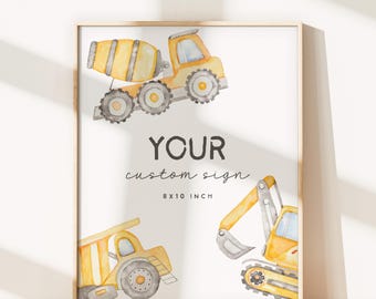 May include: A framed print featuring watercolor illustrations of construction vehicles: a cement mixer, a dump truck, and an excavator. The text "YOUR custom sign" is centered below the vehicles, with "8 x 10 inch" below the text. The frame is a light wood color.