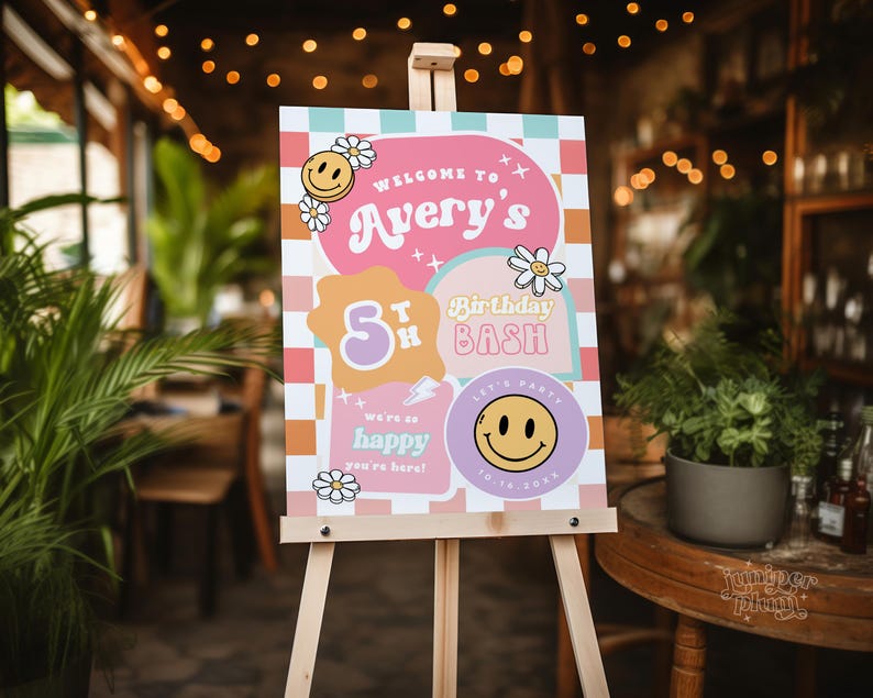 May include: A pink and orange welcome sign with a checkered background. The sign says "Welcome to Avery's 5th Birthday Bash". There are smiley faces and flowers on the sign.