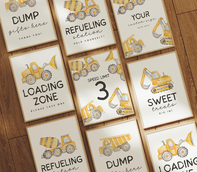 May include: A collection of framed signs with watercolor illustrations of construction vehicles. The signs feature text such as "DUMP gifts here," "REFUELING station," "LOADING ZONE," and "SWEET treats." The signs are in a neutral color palette.