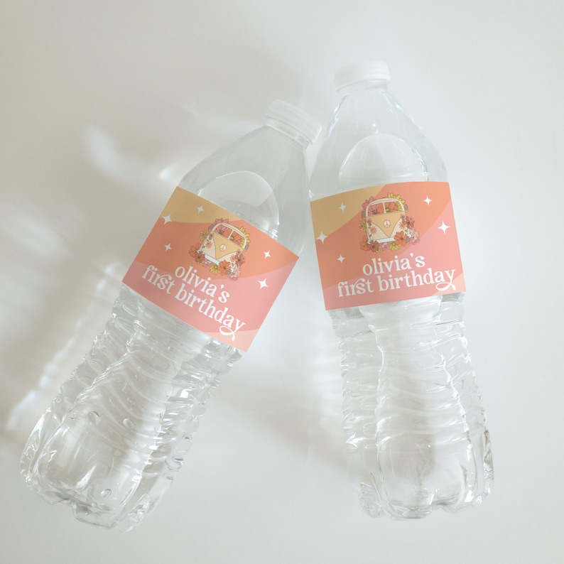 Puede incluir: Dos botellas de agua de pl&aacute;stico transparente con etiquetas personalizadas. Las etiquetas son rosas y naranjas con un dise&ntilde;o floral y una furgoneta vintage. El texto en las etiquetas dice "Olivia's first birthday".