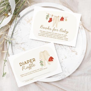 May include: Two baby shower invitation cards. One card reads "Books for Baby" with text and illustrations of baby clothes. The other card reads "Diaper Raffle" with text and illustrations of baby clothes.