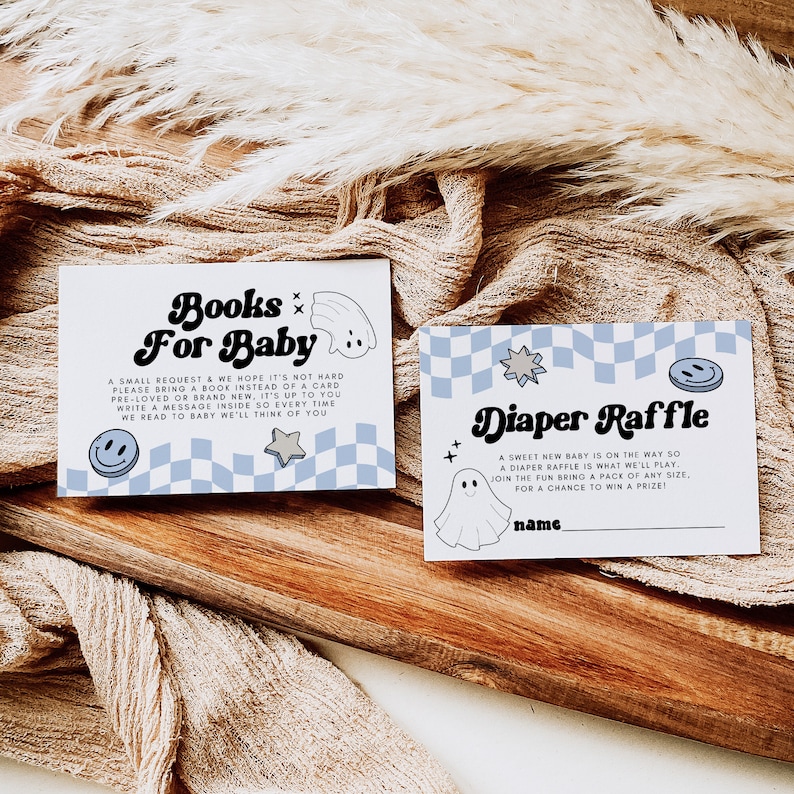 May include: Two blue and white checkered cards with a ghost and rainbow design. The text on the cards reads "Books for Baby" and "Diaper Raffle".