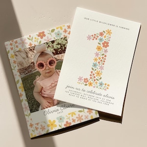 May include: Two invitations for a first birthday celebration. One features a photo of a baby wearing sunglasses, the other has a floral number one. Text includes "Our Little Wildflower is Turning" and party details.