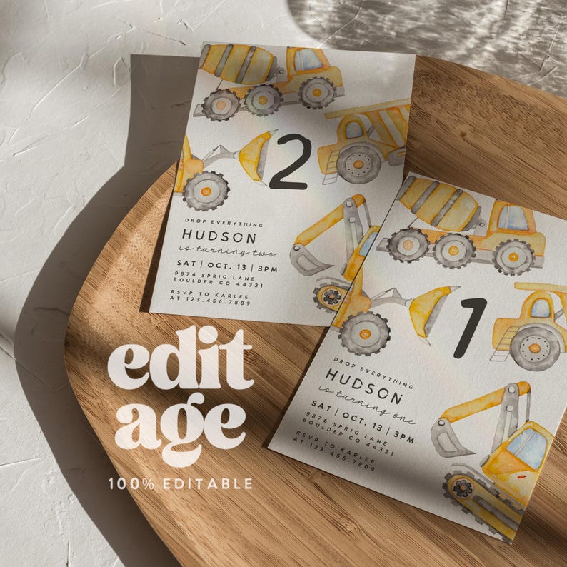May include: Two birthday invitations featuring watercolor illustrations of construction vehicles in yellow and gray. The invitations include the text "HUDSON is turning two" and "HUDSON is turning one". The invitations are on a wooden surface.