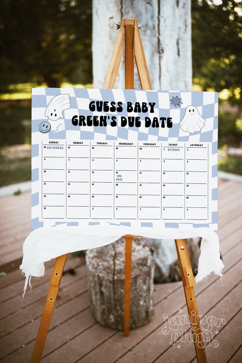 May include: A white and blue checkered sign with the text "Guess Baby Green's Due Date" and a calendar grid with dates from September 24th to October 6th. The sign has a ghost and a smiley face graphic.