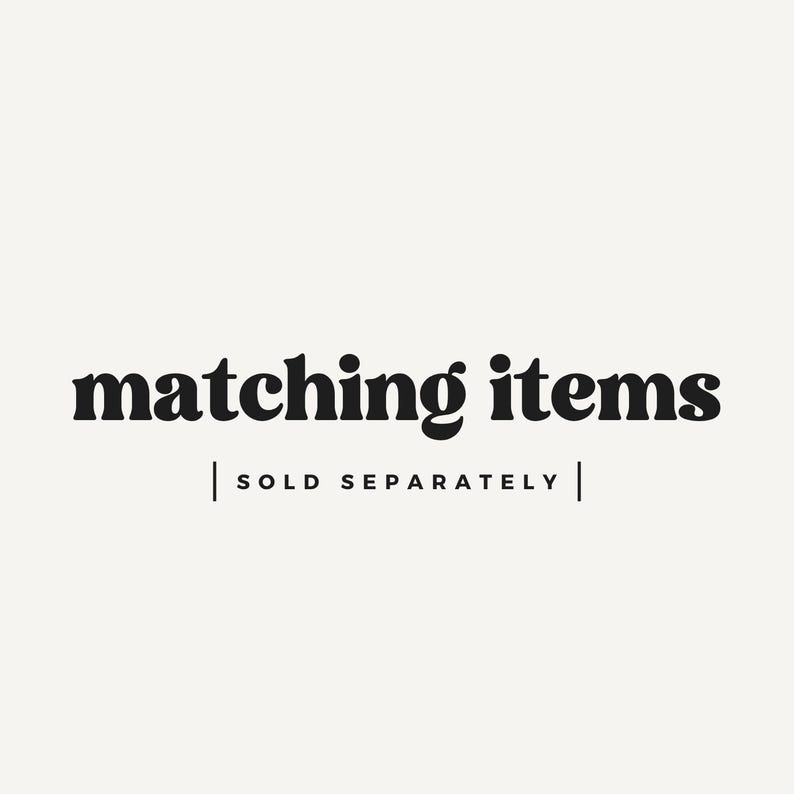 May include: Image with the text "matching items" in a bold, black font. Below the text is the phrase "SOLD SEPARATELY" in a smaller, black font, separated by vertical lines. The background is a solid, off-white color.