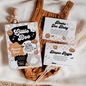 May include: A set of baby shower invitations and inserts with a Halloween theme. The main invitation features the text "Little Boo" with a ghost and smiley face. Inserts include "Books for Baby" and "Diaper Raffle" cards.