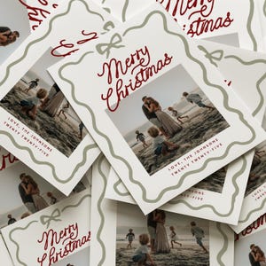 Pode incluir: Cart&otilde;es de Natal brancos com foto de fam&iacute;lia. Os cart&otilde;es t&ecirc;m uma inscri&ccedil;&atilde;o vermelha "Merry Christmas" e uma borda verde ondulada. A foto mostra uma fam&iacute;lia na praia. O texto na parte inferior diz "Love, The Johnsons Twenty Twenty-Five".