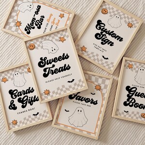 May include: A collection of framed Halloween-themed signs with a beige and white checkered background. The signs feature phrases like "Mom-osa Bar," "Sweets Treats," and "Cards & Gifts" in a retro font, along with ghost and star illustrations.