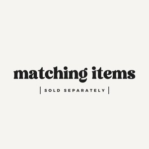 May include: Image with the text "matching items" in a bold, black font. Below the text is the phrase "SOLD SEPARATELY" in a smaller, black font, separated by vertical lines. The background is a solid, off-white color.