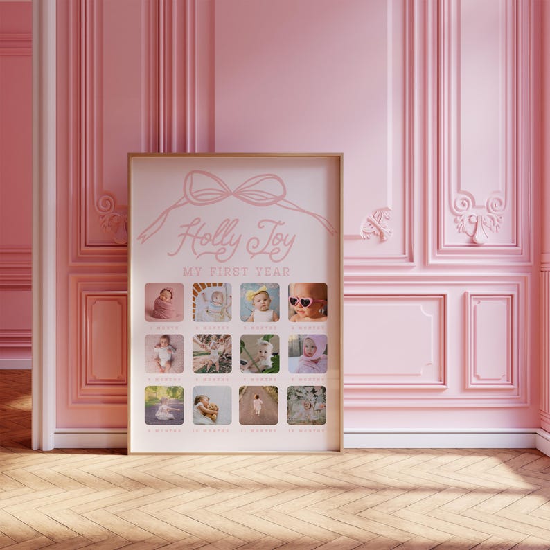 May include: A framed baby photo collage titled "Holly Joy My First Year." The pink and gold frame displays 12 small photos, each representing a month. The top features a bow design and the baby's name in cursive.