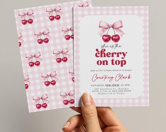 May include: Baby shower invitation featuring a cherry theme. The invitation has a pink gingham background and a design with cherries and bows. The text reads "she is the cherry on top" and includes event details.