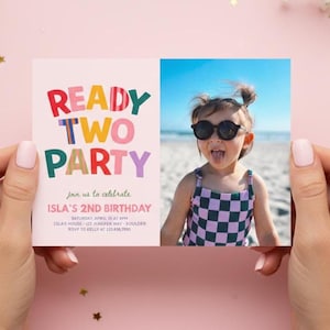 May include: A pink birthday invitation card with the words "READY TWO PARTY" in bright colours. The card includes a photo of a young girl wearing sunglasses and a checkered swimsuit. The invitation is for Isla's 2nd birthday.