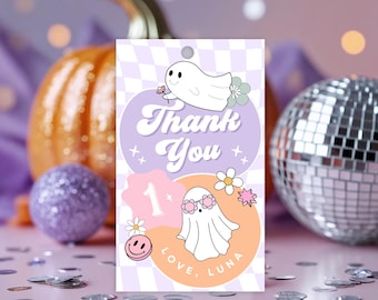 May include: A party favor tag with a ghost theme. The tag features the words "Thank You" in a retro font, along with a ghost wearing sunglasses and the text "Love, Luna". The background includes a pumpkin, disco ball, and confetti.
