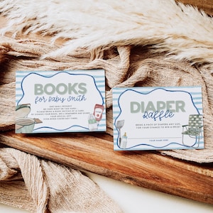 May include: Two rectangular baby shower cards with blue and white striped borders. One card reads "BOOKS for baby smith" with illustrations of a grill and condiments. The other card says "DIAPER Raffle" with a camping chair illustration.