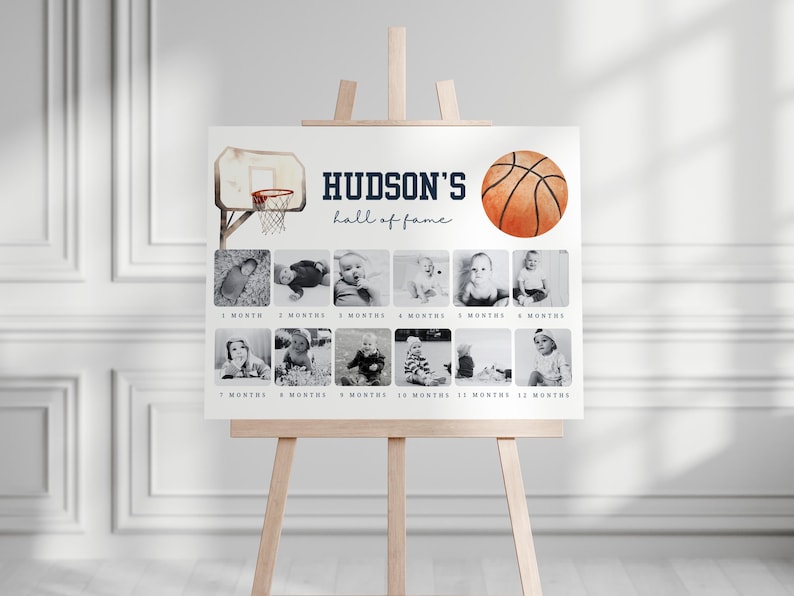 May include: A white poster with a basketball theme for a baby's first year. The poster has a basketball hoop and a basketball with the text "HUDSON'S hall of fame". There are 12 photo spaces for each month of the year.