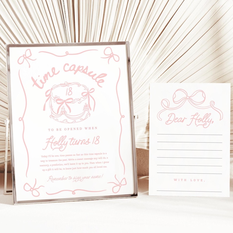 May include: A pink and white time capsule sign and card set. The sign reads "time capsule" with a cake illustration and the text "To be opened when Holly turns 18." The card says "Dear Holly" and has lines for writing.
