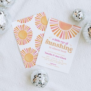 Peut inclure: Une invitation de f&ecirc;te pr&eacute;natale avec un motif de soleil &eacute;clatant rose et orange. Le texte indique "un petit rayon de soleil est presque l&agrave;" et comprend les noms "Amelia & Jace Clark".