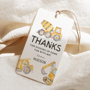 May include: A white gift tag with a watercolor illustration of construction vehicles, including a cement mixer, dump truck, and excavator. The tag reads "THANKS" and "FOR DIGGING UP SOME FUN WITH ME!" with the name "Hudson" below.