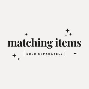 May include: A graphic with the words "matching items" in a bold, serif font. Below the text is the phrase "SOLD SEPARATELY" in a smaller font. Decorative starbursts are scattered around the text on a cream background.