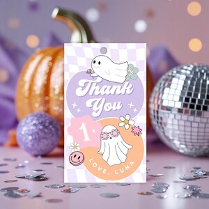 May include: A rectangular tag with a purple and white checkered background features the words "Thank You" in a retro font. The tag includes illustrations of ghosts, flowers, and the number "1", with the text "Love, Luna".