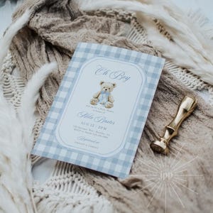 May include: A baby shower invitation with a blue gingham pattern and the words "Oh Boy." The invitation features a teddy bear illustration and event details. A gold wax seal is on the right.