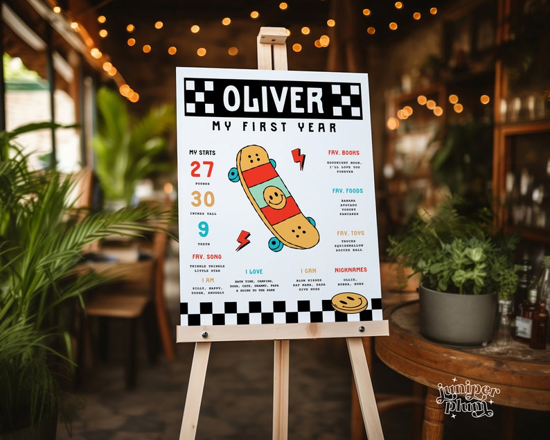 May include: A white poster with black and white checkered borders, featuring a colorful skateboard graphic and text that reads "Oliver My First Year". The poster includes details about Oliver's first year, such as his favorite songs, books, foods, and toys.