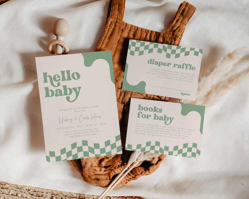 May include: A set of three rectangular paper cards with a light pink background, sage green wavy accents, and a checkered pattern. The cards feature the text hello baby, diaper raffle, and books for baby in a bold, rounded sage green font.