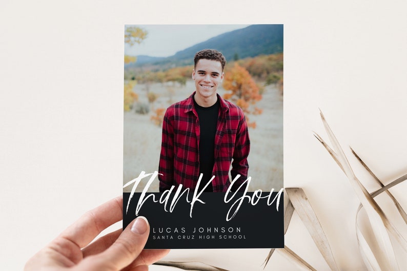May include: A black and white thank you card with a photo of a person in a red and black plaid shirt. The text "Thank You" is written in white script on a black background. The text "Lucas Johnson" and "Santa Cruz High School" is written in white on the black background.