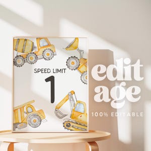 May include: A framed print featuring watercolor illustrations of construction vehicles in yellow and gray. The print includes the text "SPEED LIMIT 1". The background is white, and the frame is a light wood color.
