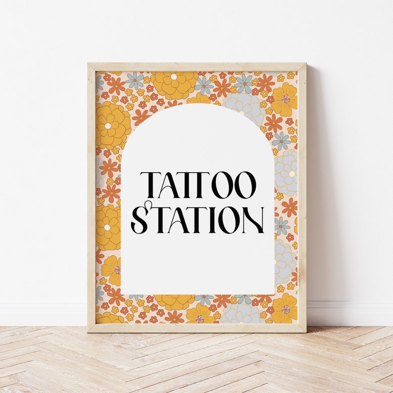 May include: A framed print with a floral pattern in shades of orange, yellow, and blue. The print features an archway with the text "TATTOO STATION" inside.