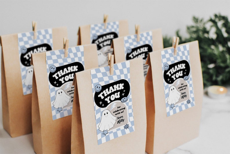 May include: Brown paper bags with blue and white checkered thank you tags. The tags feature a ghost illustration and the text "Thank You" in a retro font. The text on the tag also says "For celebrating with us! Love, [Name]"