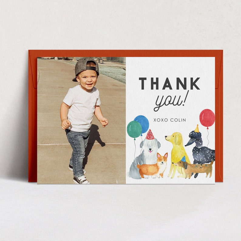May include: A thank you card with a photo of a young boy in a white shirt and blue jeans. The card features a watercolor illustration of dogs with party hats and balloons. The text on the card reads "THANK you! XOXO COLIN".