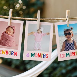 May include: Three photos hanging on a string with clothespins. Each photo has a baby or toddler. The first photo says "NEWBORN" in colorful letters. The second photo says "6 MONTHS". The third photo says "12 MONTHS".