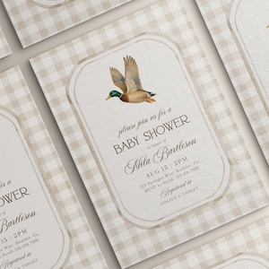 May include: Baby shower invitations with a duck illustration. The invitations have a beige gingham background and a cream-colored frame with the text "Baby Shower" and event details. The duck is brown, green, and orange.