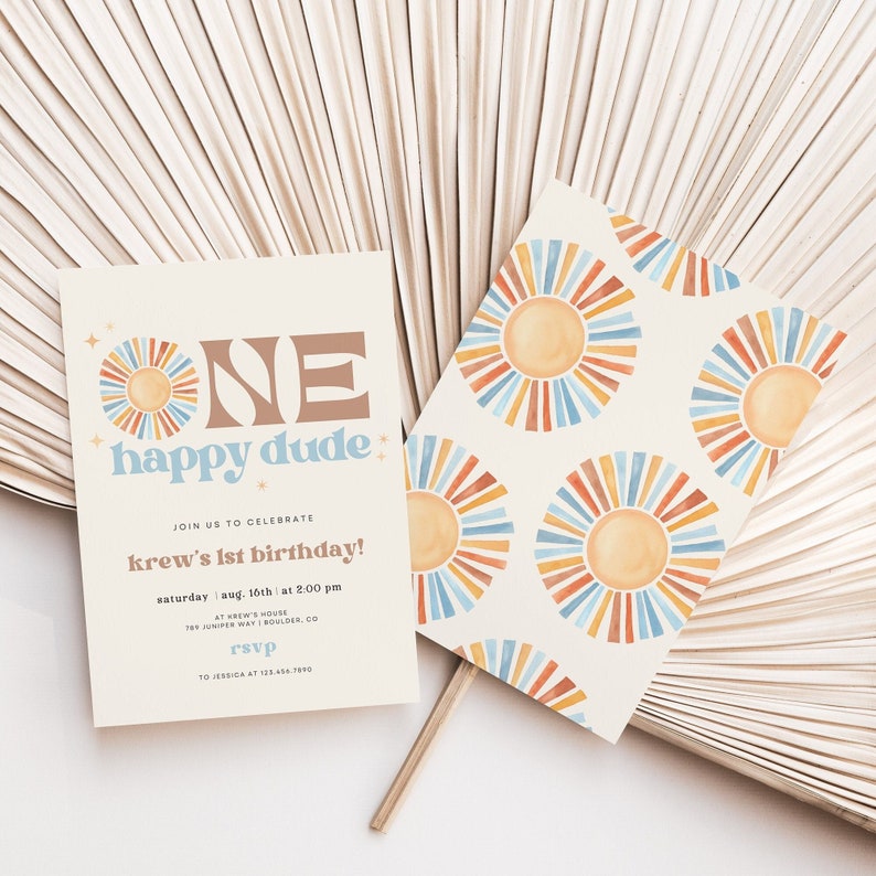 May include: A set of birthday party invitations with a retro sun design. The invitation reads "ONE happy dude" and includes event details. The matching card features a repeating sun pattern in orange, blue, and yellow. The background is a neutral color.