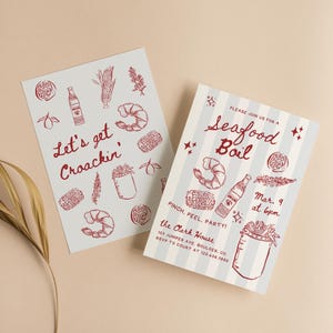 K&ouml;nnte beinhalten: Zwei hellblaue Einladungen mit roten Meeresfr&uuml;chte-Illustrationen und Text. Auf einer steht "Let's get Croackin'" und auf der anderen "Seafood Boil" mit Veranstaltungsdetails. Die Einladungen sind f&uuml;r eine Meeresfr&uuml;chteparty.