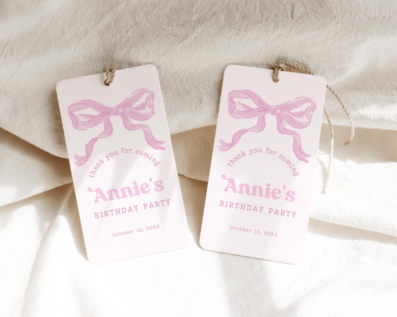 May include: Two rectangular gift tags with a light pink background. Each tag features a watercolor-style pink bow and the text "thank you for coming" above "Annie's BIRTHDAY PARTY" and the date "October 13, 20XX".