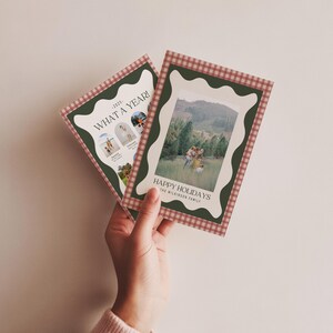 May include: Two holiday cards with a green and red gingham border. One card reads "WHAT A YEAR!" with photos. The other card says "HAPPY HOLIDAYS" with a family photo. The cards have a scalloped edge.