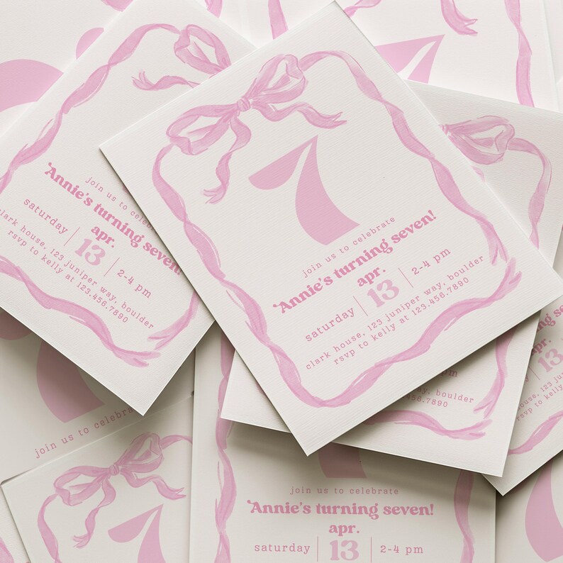 May include: Pink and white invitation cards with a pink ribbon and bow design. The text on the cards reads "Annie's turning seven!" with the date "April 13th" and the time "2-4 pm".