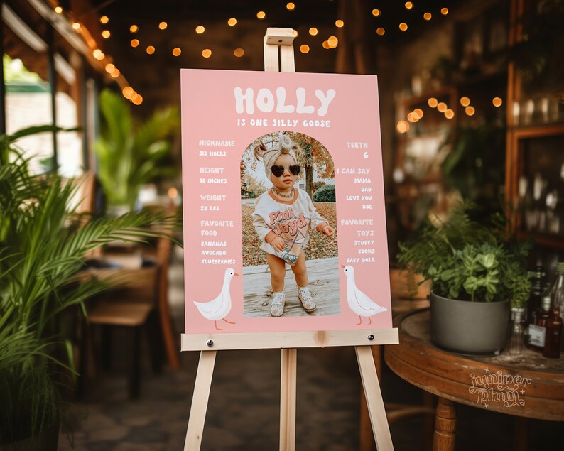 K&ouml;nnte beinhalten: Ein rosa-wei&szlig;es Schild mit dem Namen "HOLLY" in einer verspielten Schriftart. Das Schild listet Informationen &uuml;ber Holly auf, darunter ihren Spitznamen, ihre Gr&ouml;&szlig;e, ihr Gewicht, ihre Lieblingsessen und ihre Lieblingsspielzeuge. Ein Foto von Holly ist auf dem Schild enthalten.