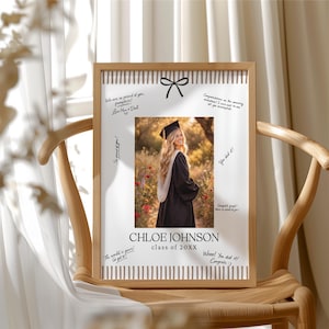 Pode incluir: Uma foto de formatura emoldurada com uma graduada em traje e chap&eacute;u. A moldura marrom claro tem uma borda listrada. A foto inclui o nome "CHLOE JOHNSON" e "class of 20XX". Mensagens de parab&eacute;ns manuscritas circundam a foto.