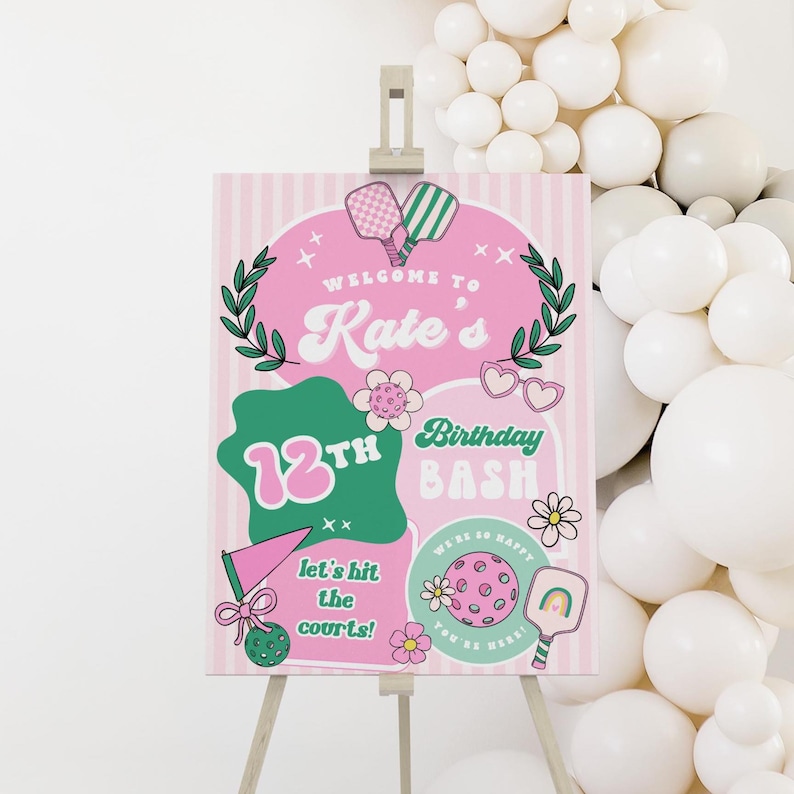 May include: A pink and white striped welcome sign for a 12th birthday party. The sign features the text "Welcome to Kate's 12th Birthday Bash" with pickleball-themed graphics and the phrase "Let's hit the courts!"