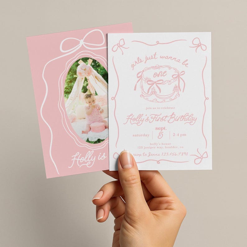 May include: Two pink birthday invitations. One features a photo of a baby, the other has text that reads "girls just wanna be one" and "Holly's First Birthday". The invitations have bow and ribbon designs.