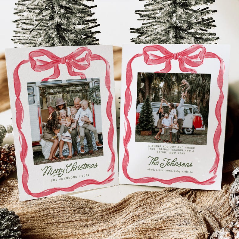 May include: Two Christmas cards featuring family photographs, framed with a red watercolour ribbon and bow design. One card reads "Merry Christmas" and "The Johnsons 2024." The other card says "Wishing you joy and cheer this holiday season and a bright new year."