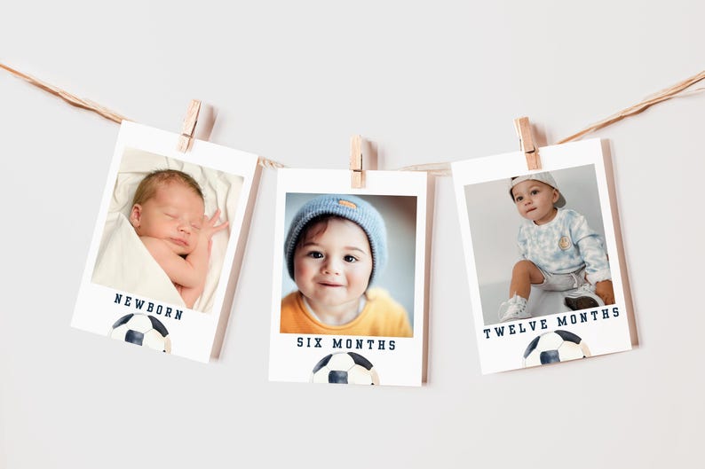 May include: Three white photo frames with black borders, each showing a baby at different ages. The frames are hung on a string with clothespins. The frames are labeled "Newborn", "Six Months", and "Twelve Months". Each frame has a soccer ball graphic at the bottom.